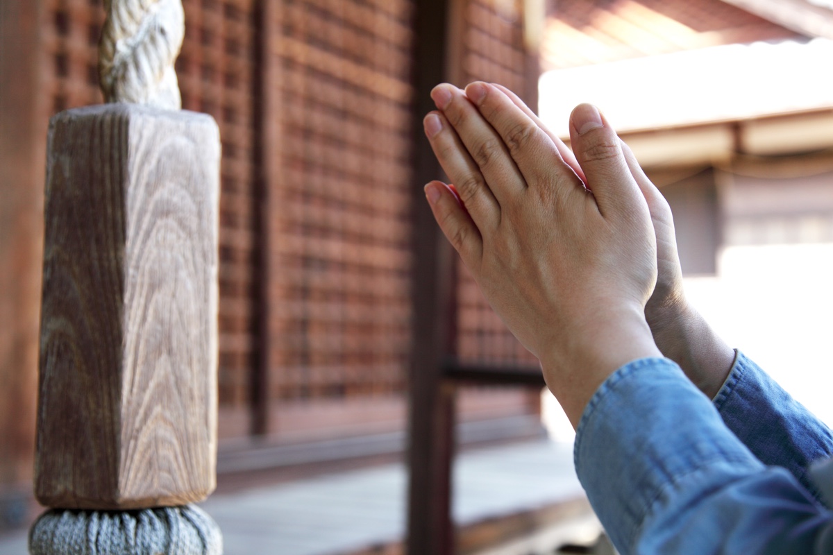 神社で手を合わせている写真